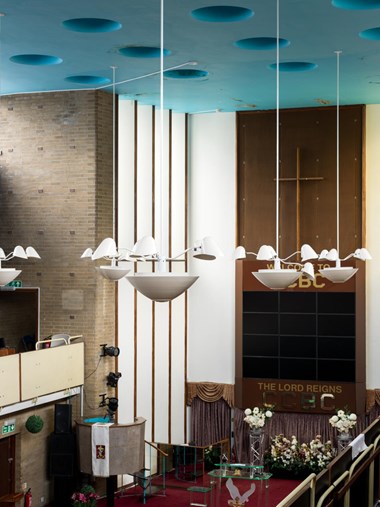 interior of a modern church with very high ceiling in blue and suspended lighting