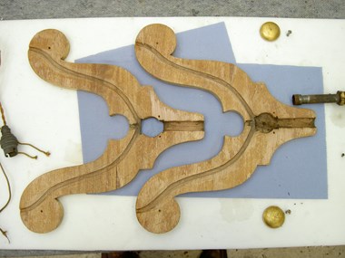 Two wooden light fittings laid out on a blue tissue on white surface.