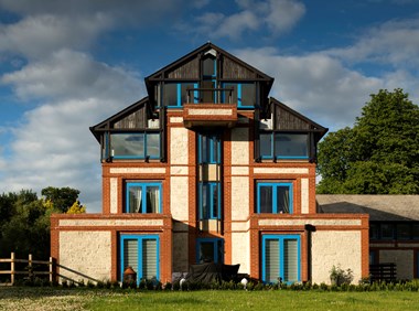 Four storey building which gets narrower as you go up with bright blue window frames